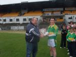 Captain Conor Small receives the trophy from Co. Antrim Youth Officer Tony McCollum